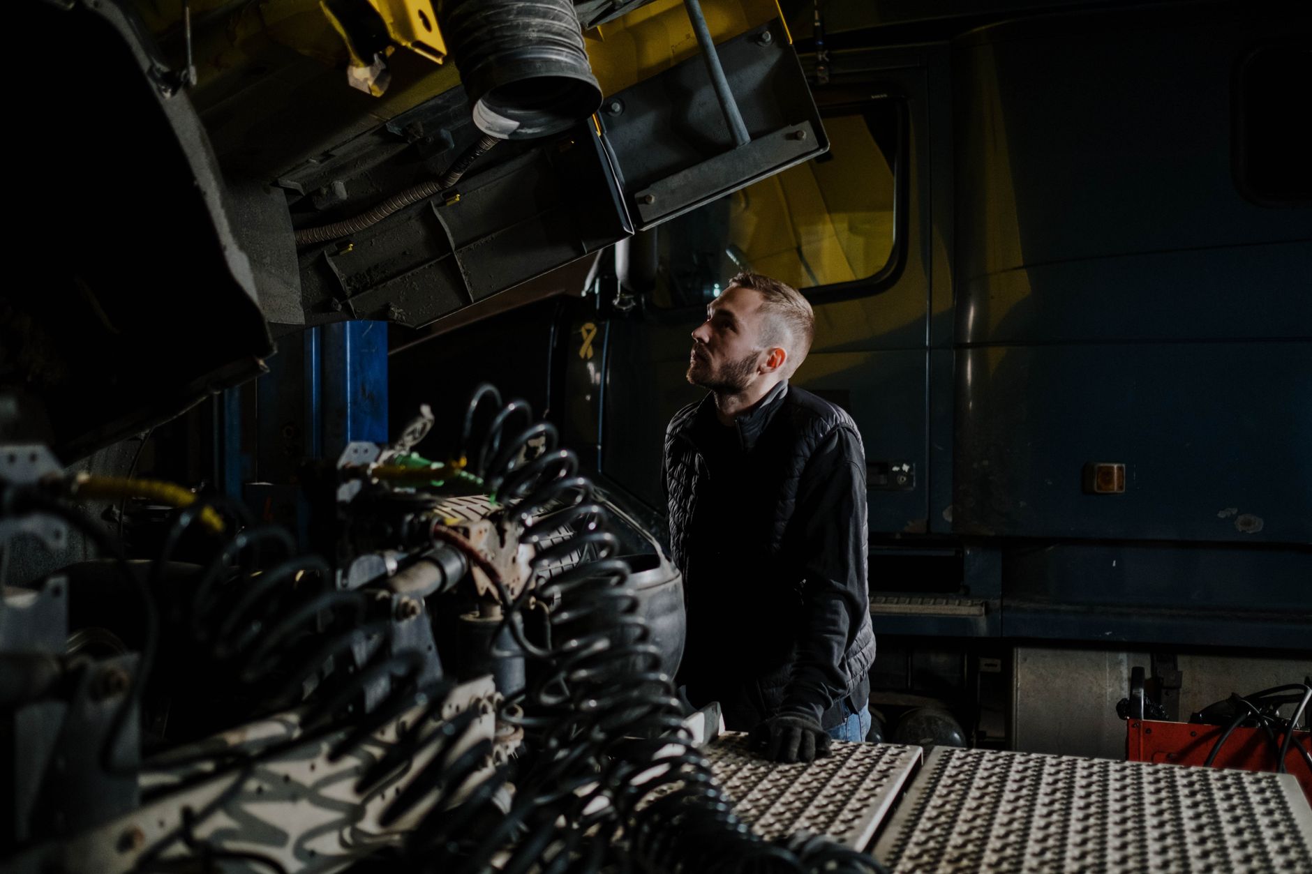 Mechanik w warsztacie sprawdza silnik ciężarówki