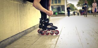 Rolkarz w miejskim parku precyzyjnie reguluje swoje rolki slalomowe