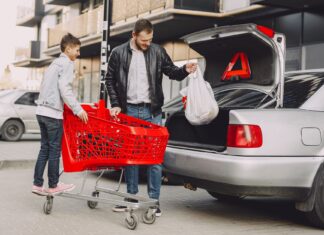 Jak przygotować samochód do długiej trasy: kompletny poradnik przeglądu, pakowania i bezpieczeństwa Mężczyzna z chłopcem pakują zakupy do bagażnika auta przed podróżą