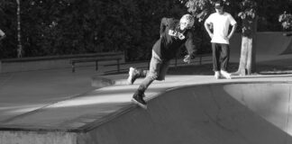 Skater wykonujący trik w skateparku w czerni i bieli
